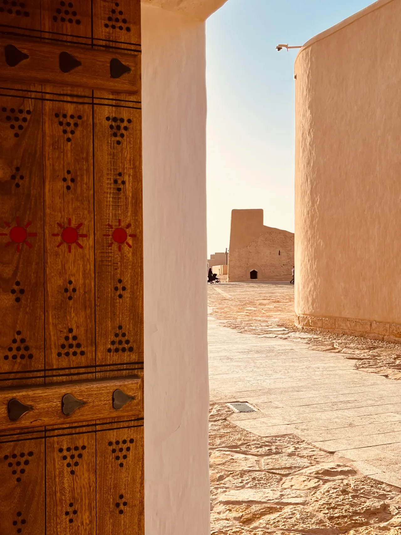 An open decorated door and sunlit courtyard