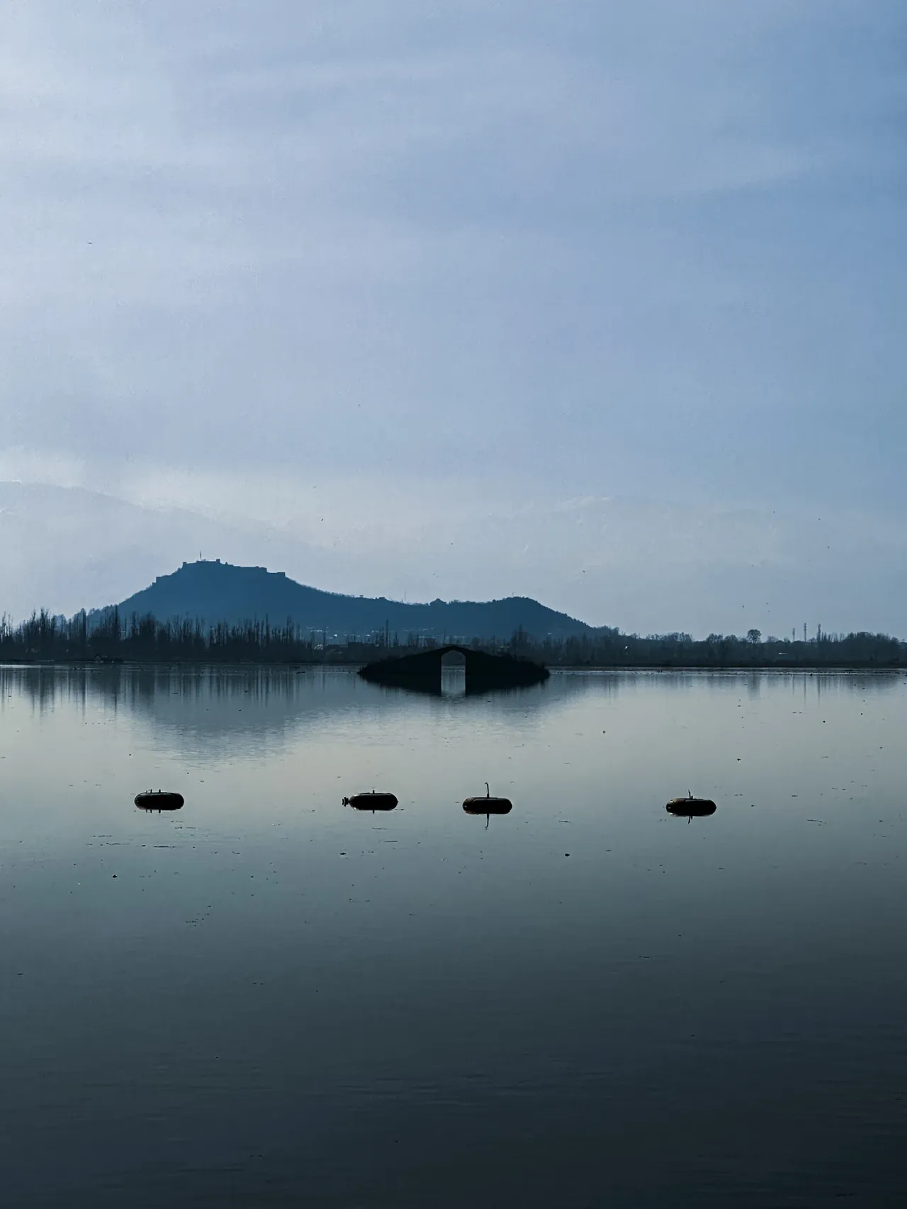 Still water beneath distant hills